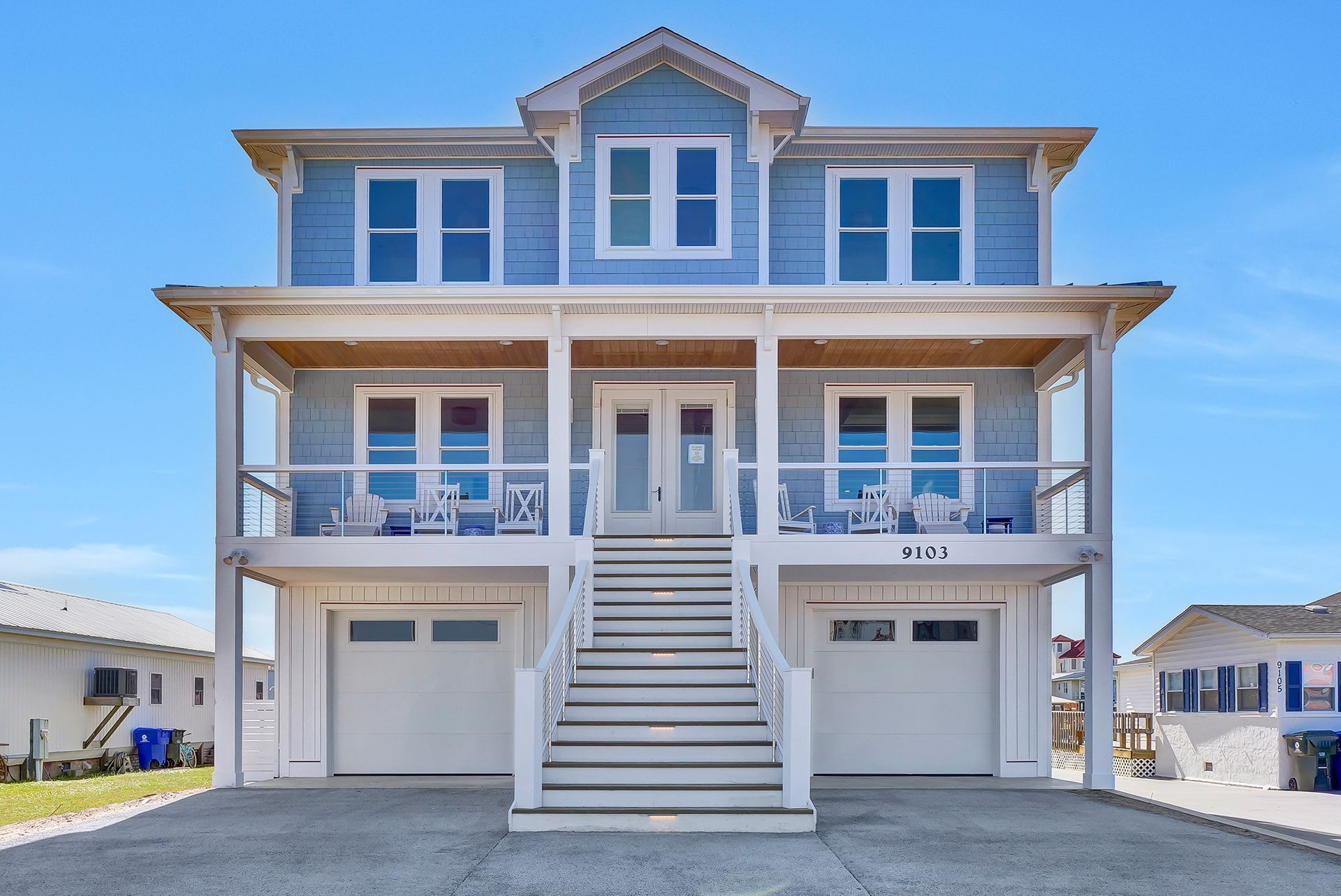 A large blue and white house with stairs leading up to it