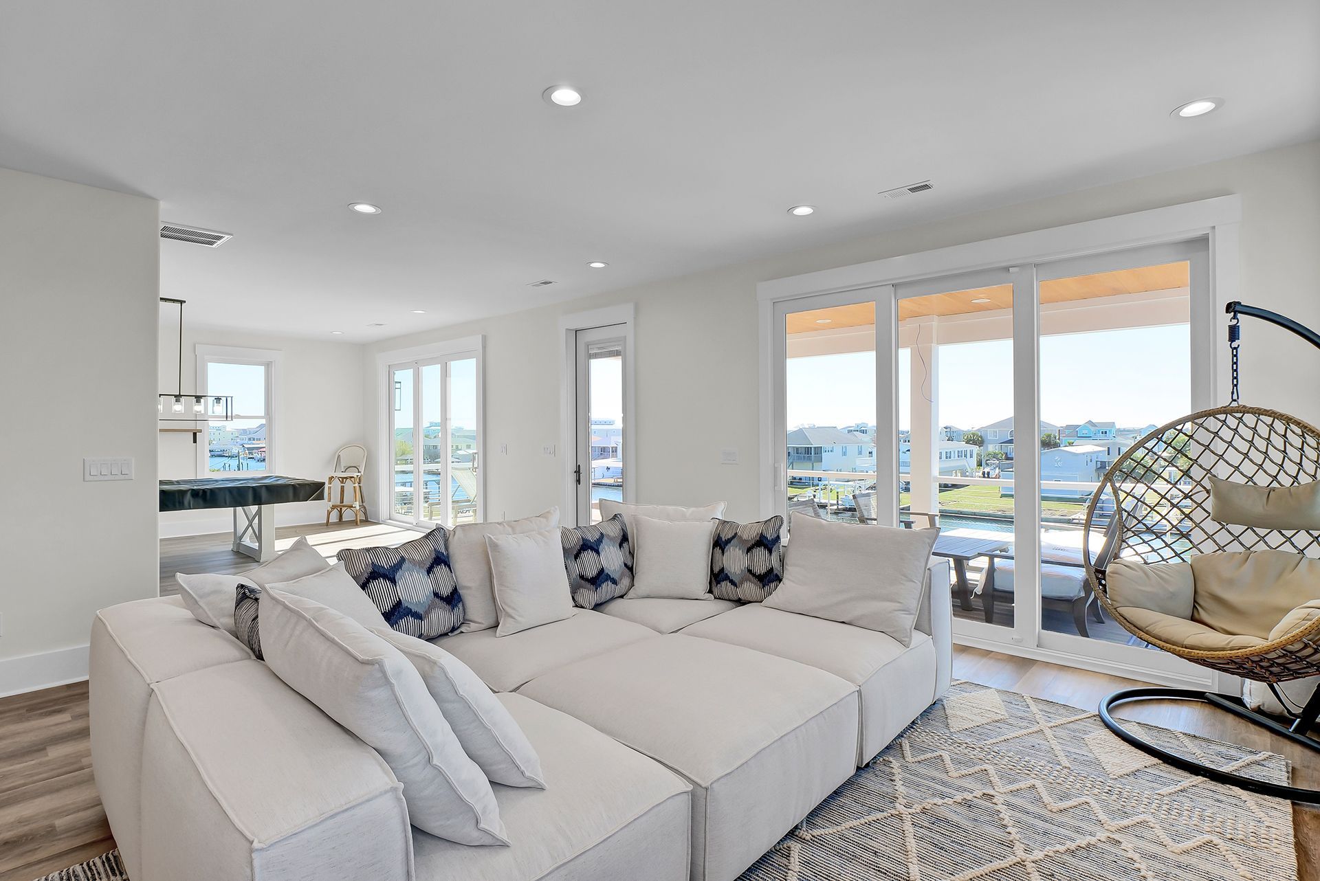 A living room with a large white couch and a hanging chair