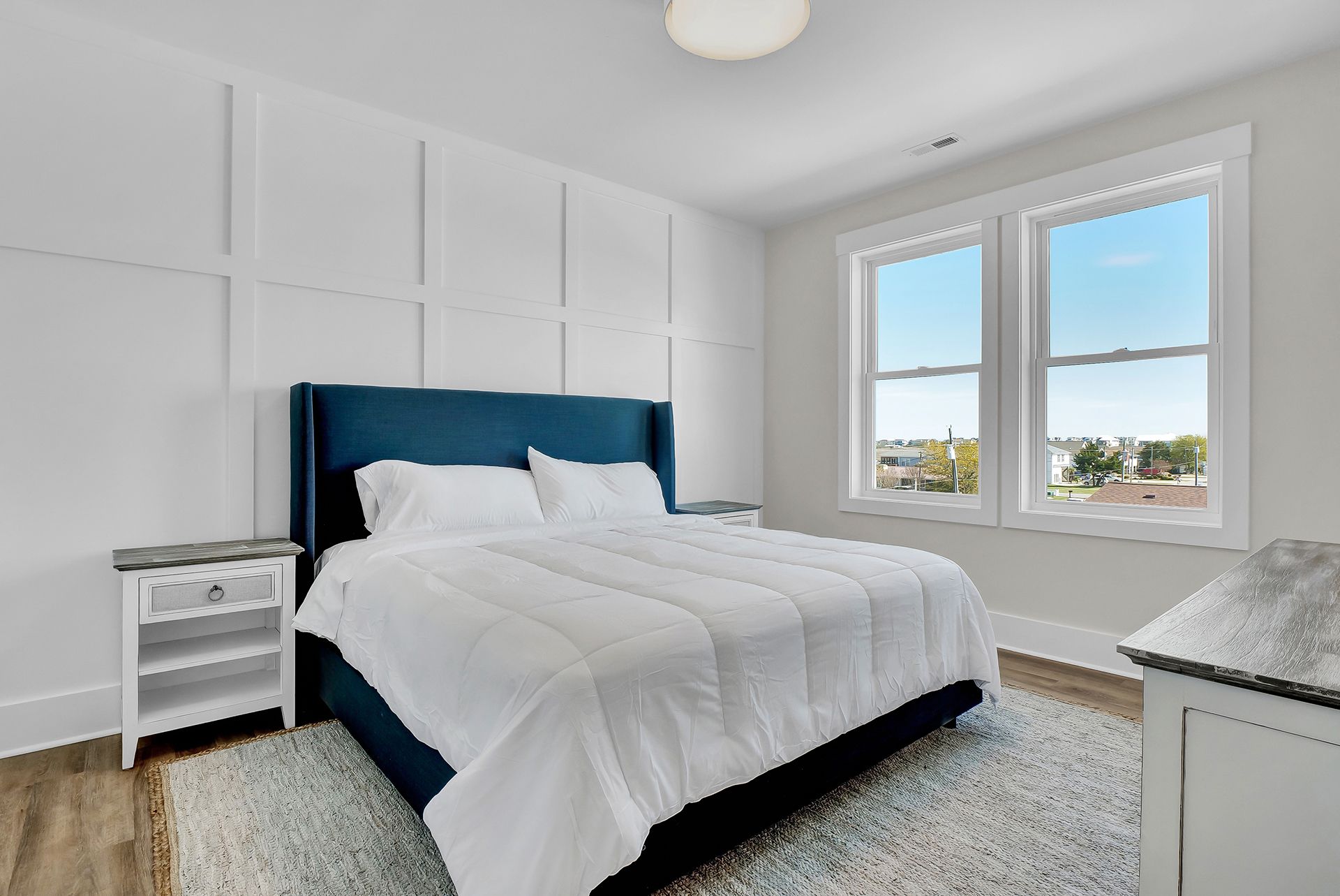 A bedroom with a king-size bed and two windows