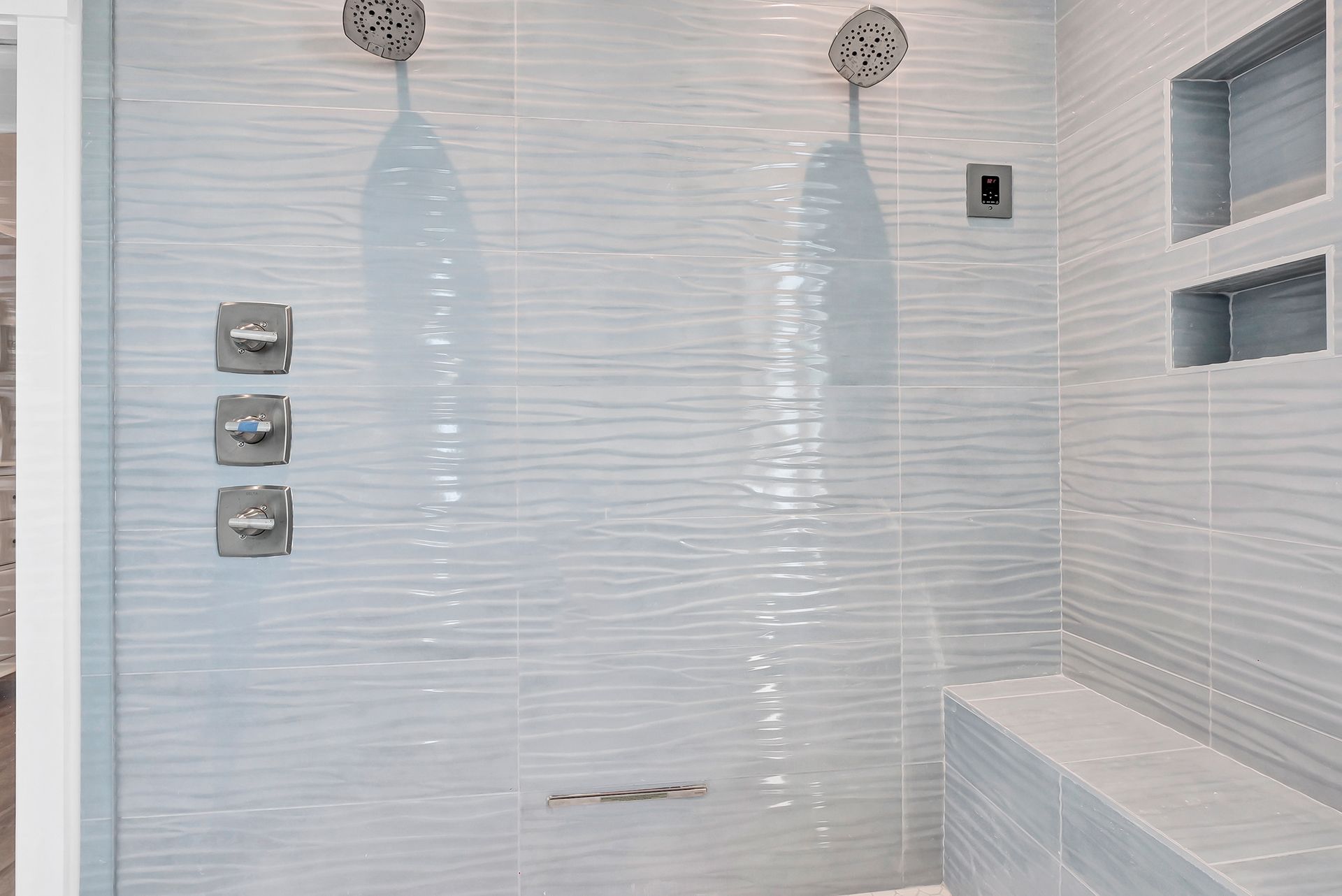 A bathroom with two shower heads