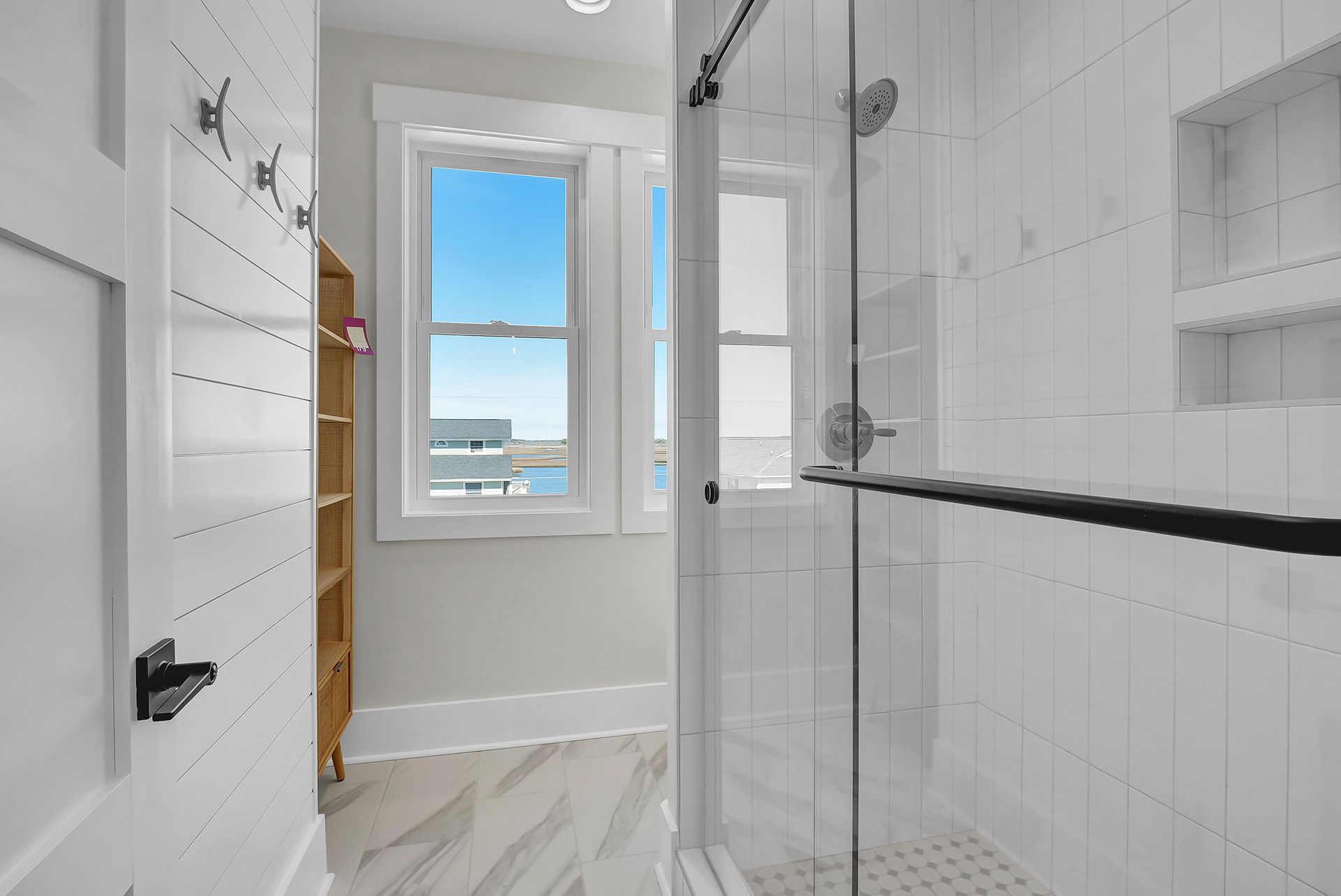 A bathroom with a walk-in shower with a glass door