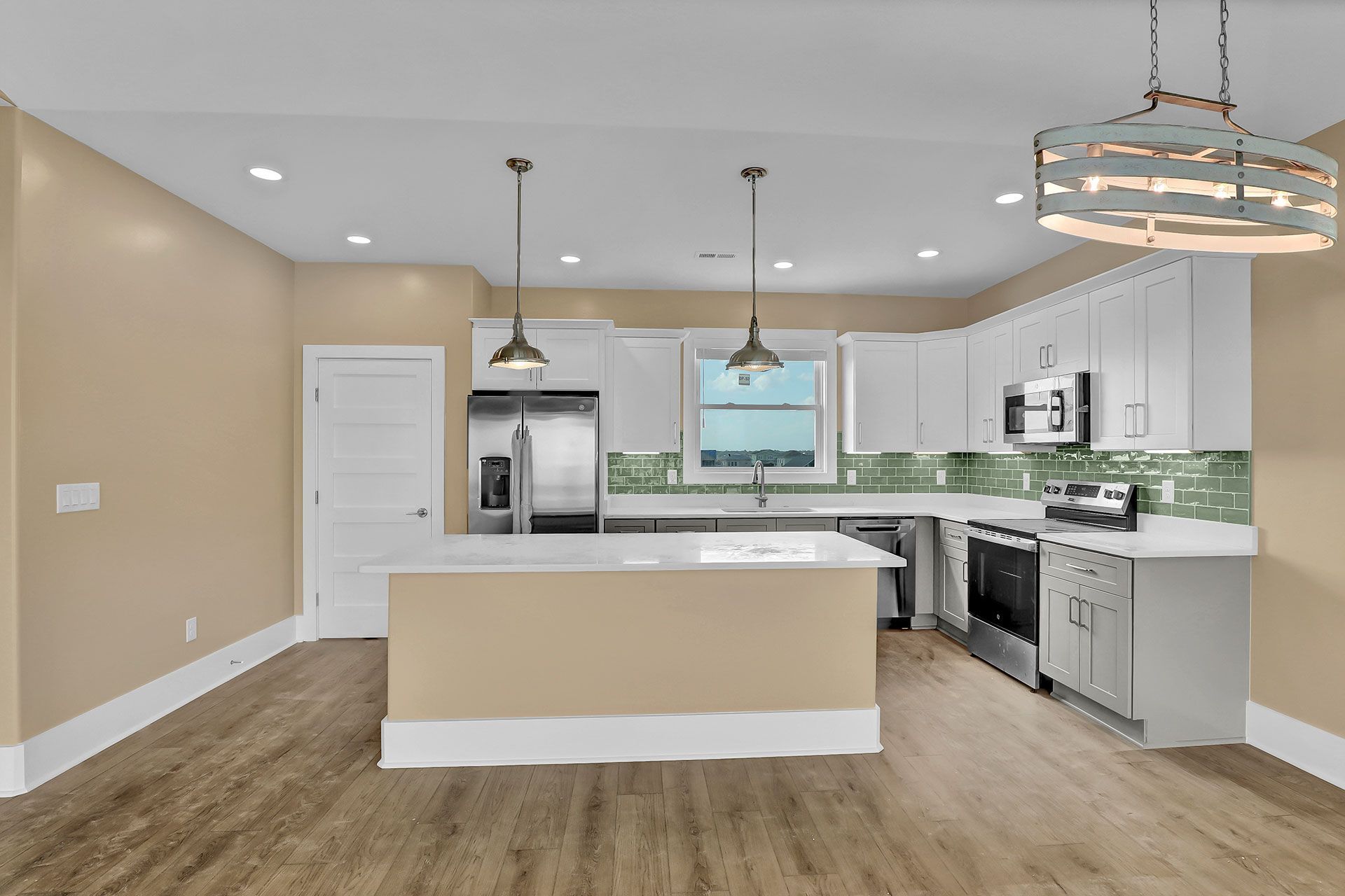 Modern kitchen with white cabinets, stainless steel appliances, and an island.