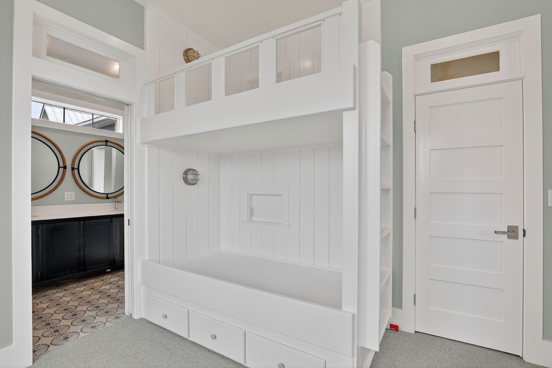 White bunk beds in a bedroom; bathroom visible through doorway.