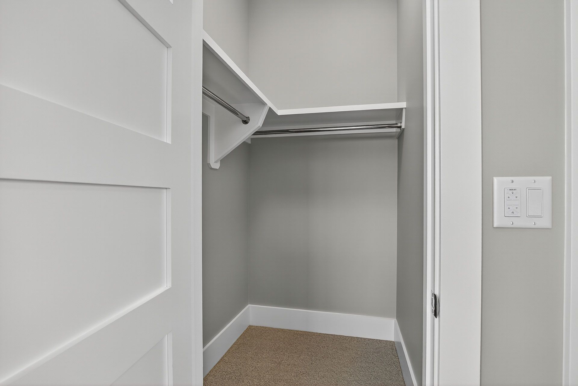 Small, empty closet with white trim, gray walls, and a single shelf and rod.