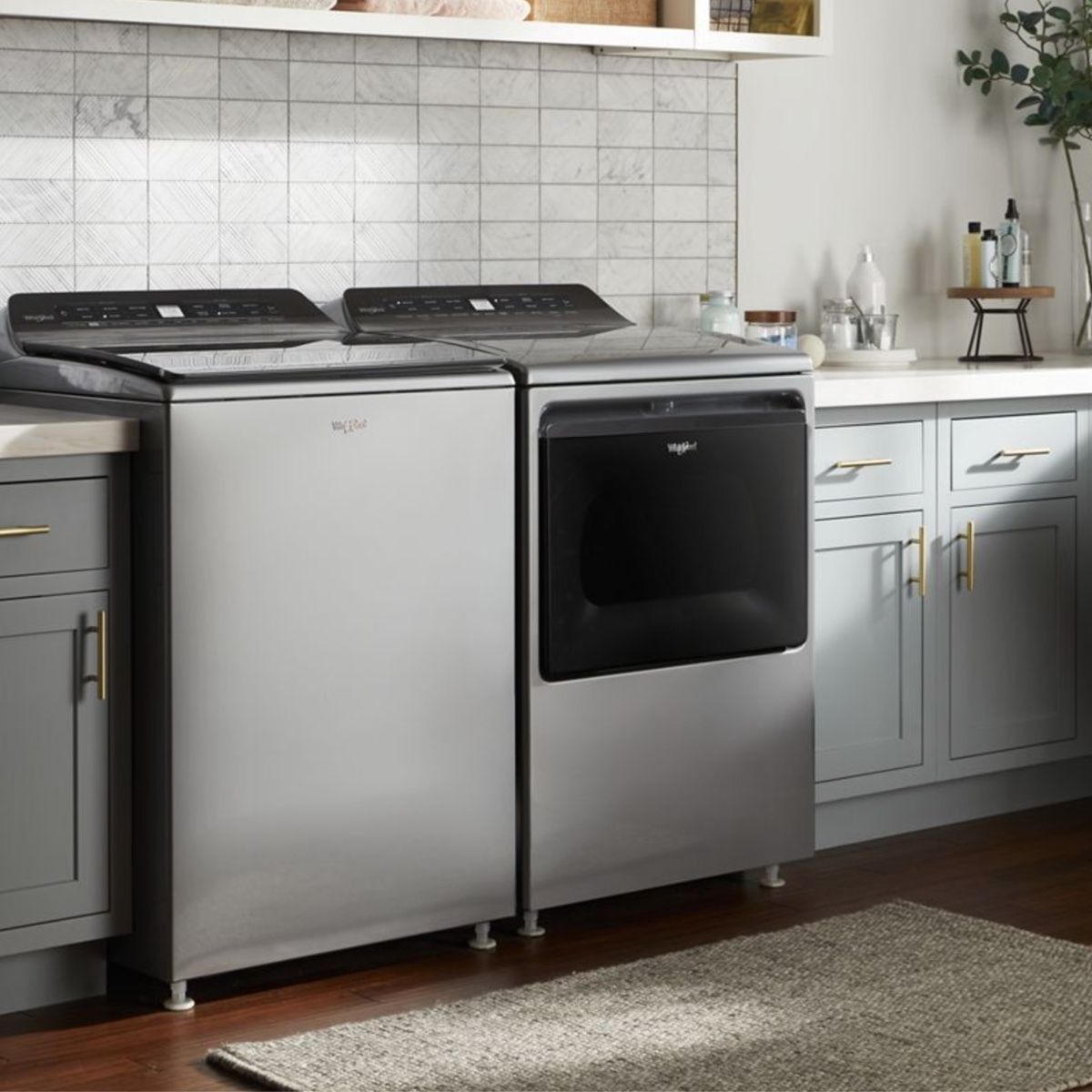 A laundry room with a washer and dryer and a rug