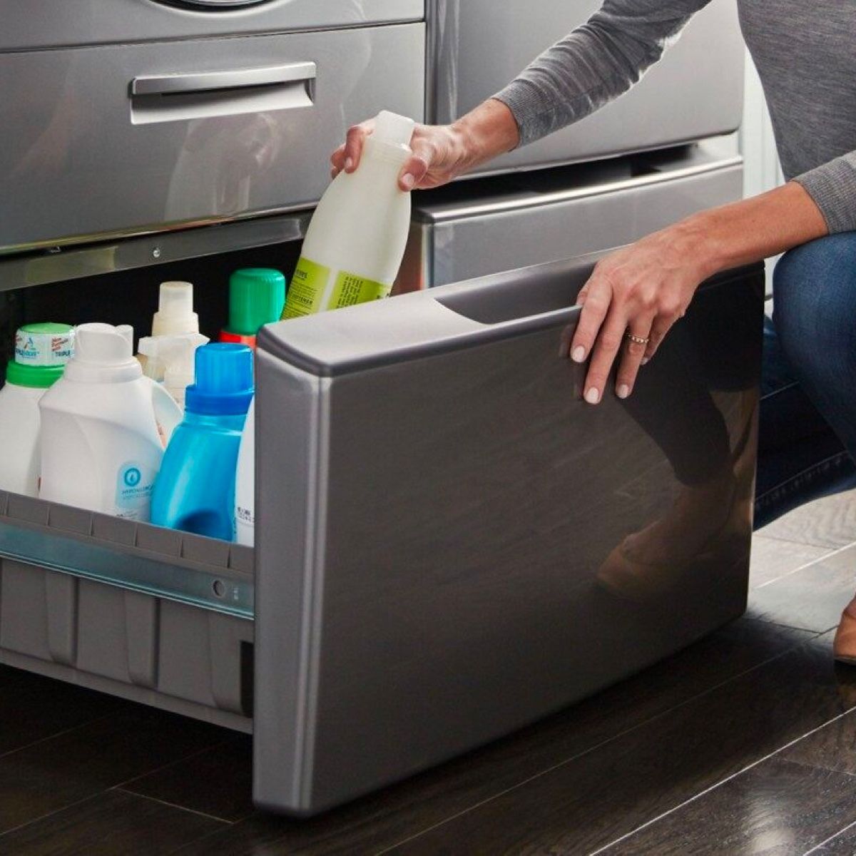 A woman is pouring milk into a laundry drawer