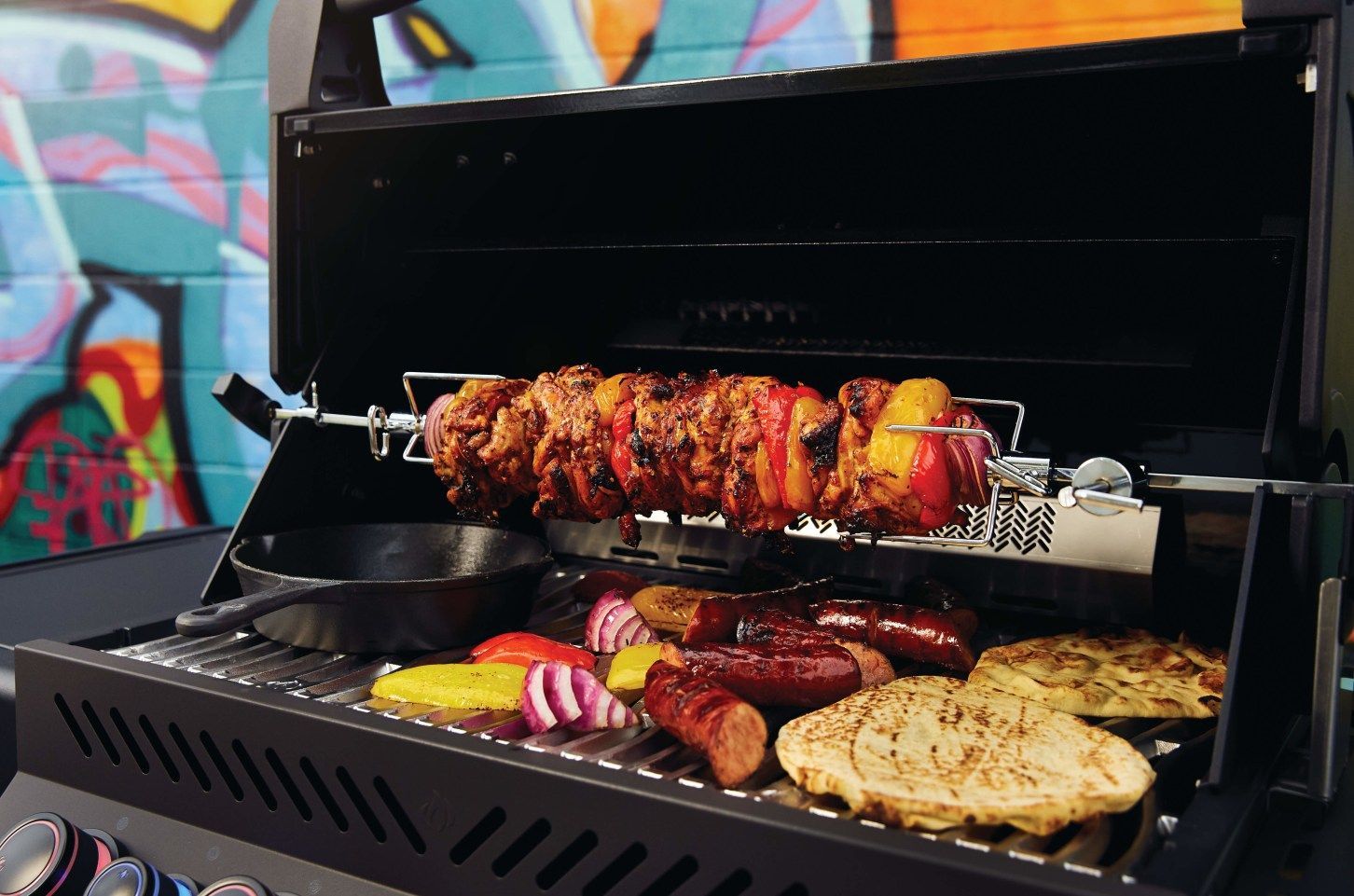 A grill with meat and vegetables cooking on it.