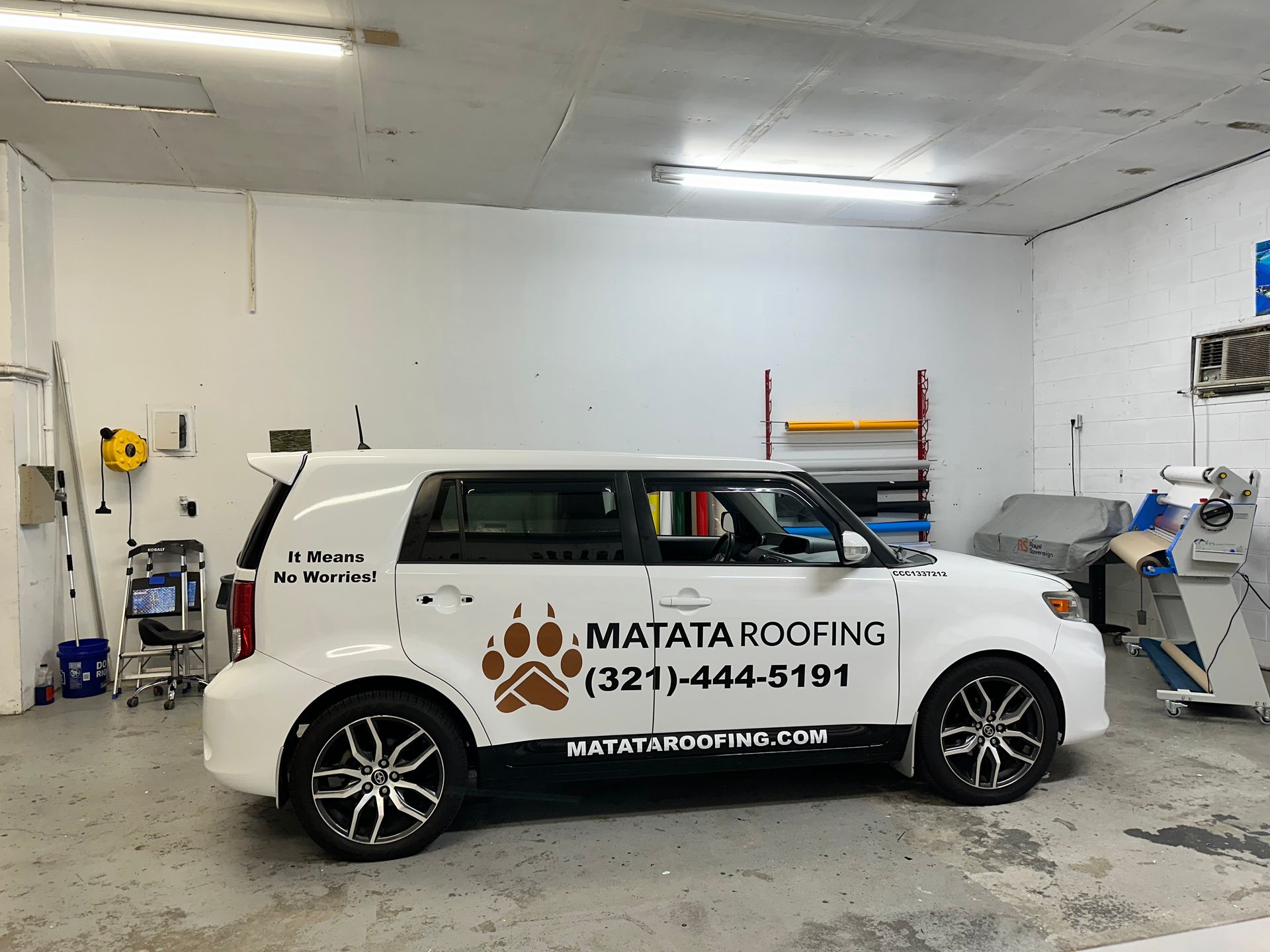White SUV with Matador Plumbing logo and phone number parked inside a garage/workshop
