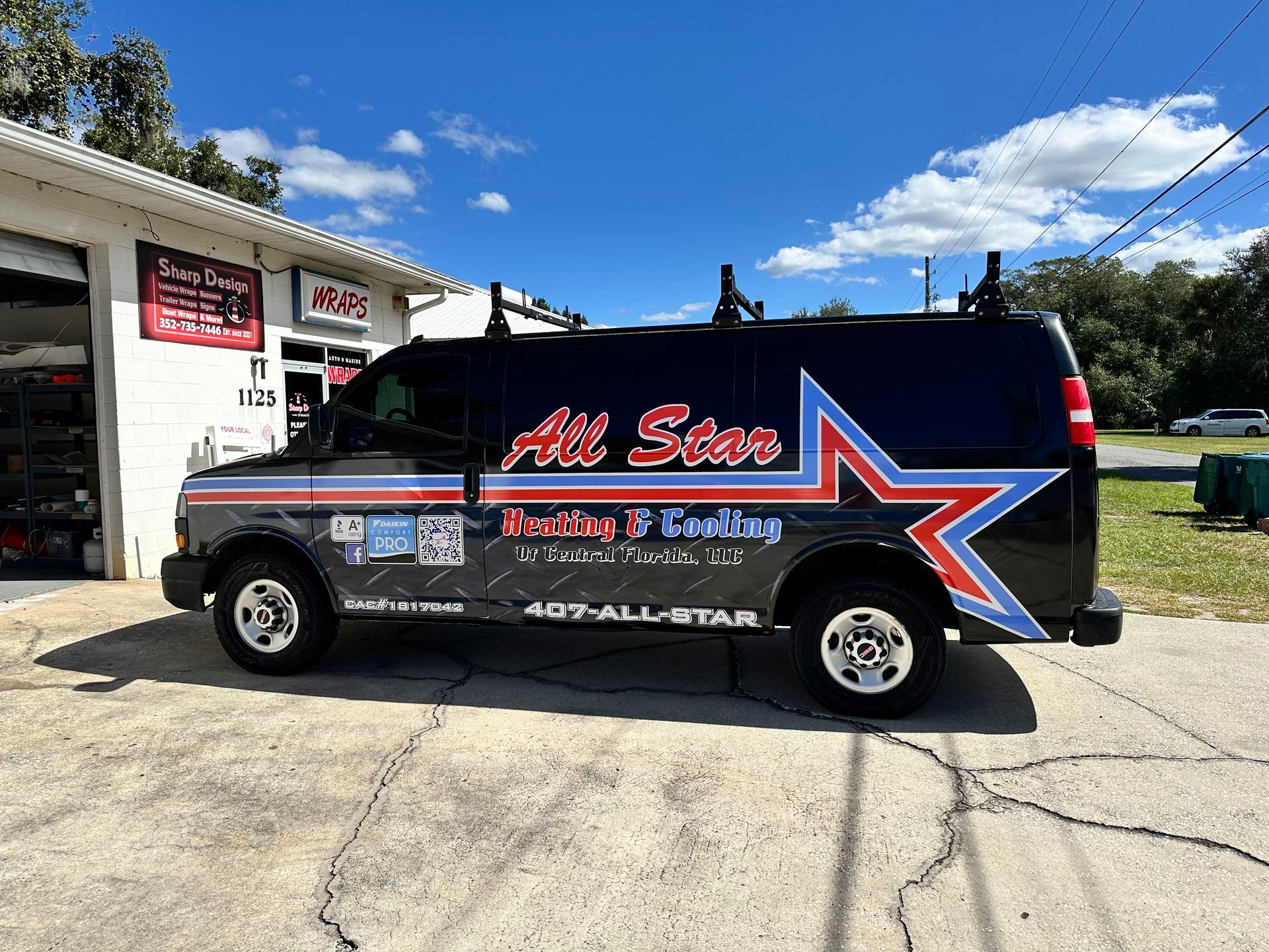 Black All Star HVAC service van parked outside a shop on a sunny day