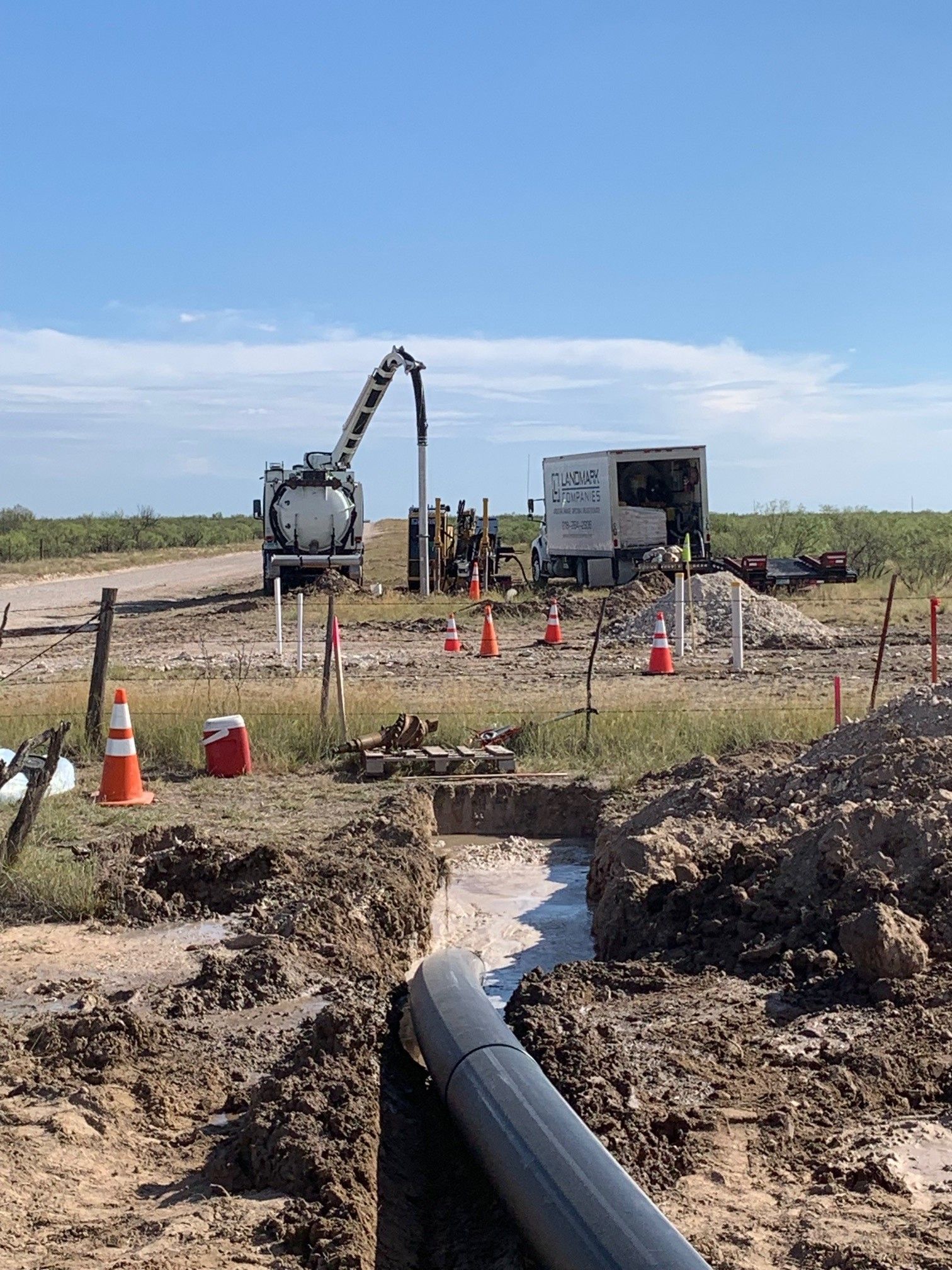 a large pipe is being installed in a dirt field .