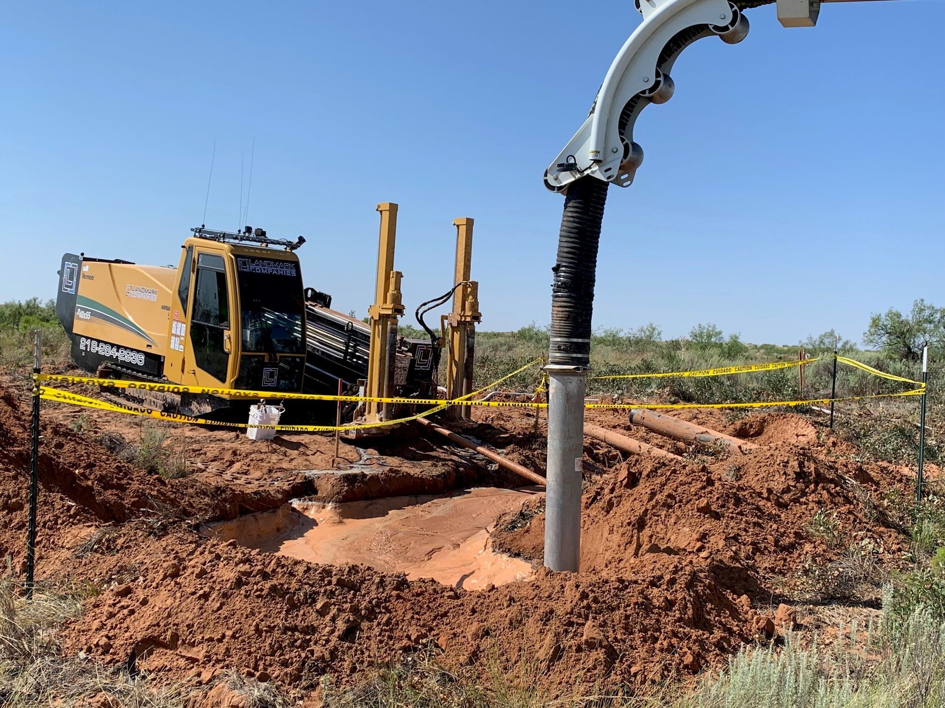 a large yellow machine is digging a hole in the dirt .