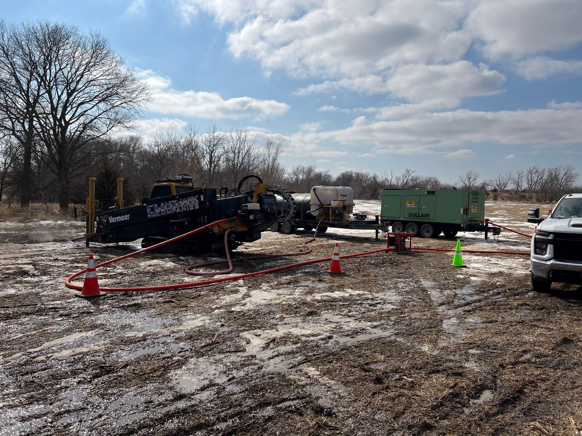 a truck is parked in the middle of a muddy field .