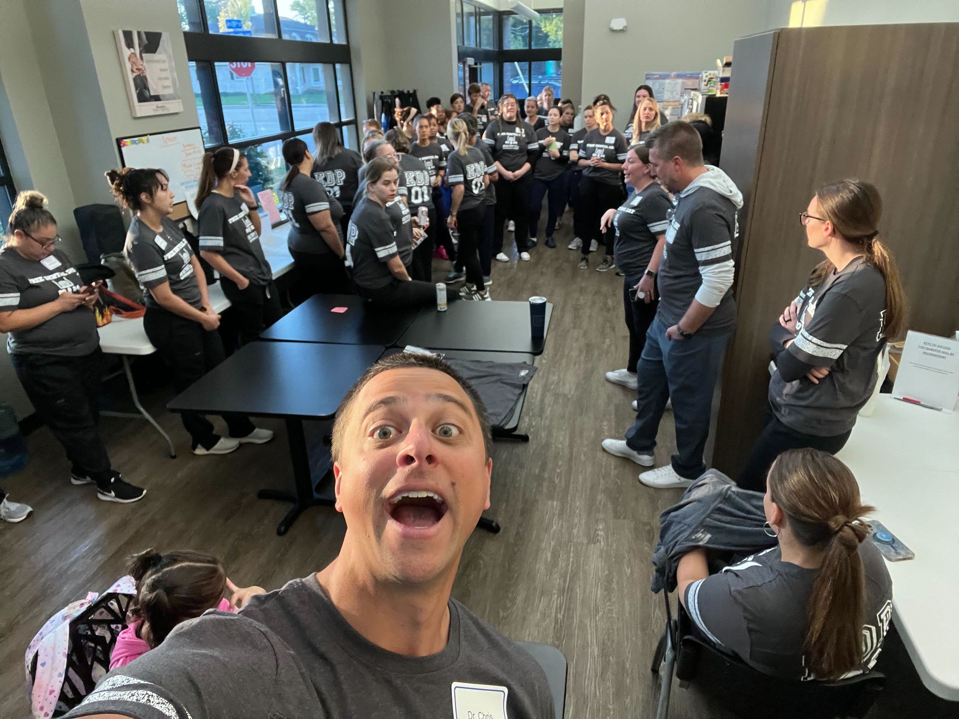 A man is taking a selfie in front of a group of people.