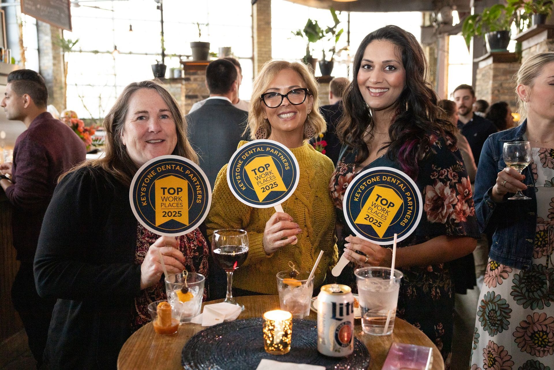 A group of women are sitting at a table holding signs.