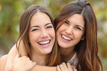 two women are hugging each other and smiling for the camera