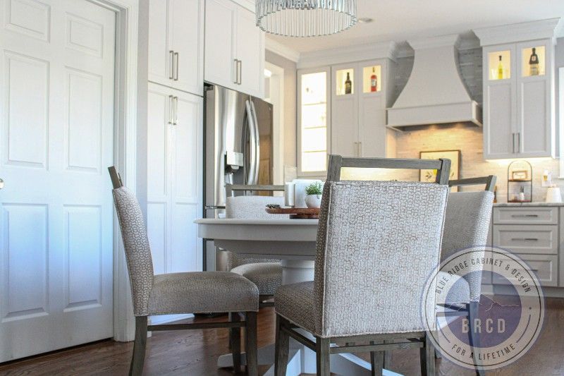 A kitchen with a table and chairs and a refrigerator.