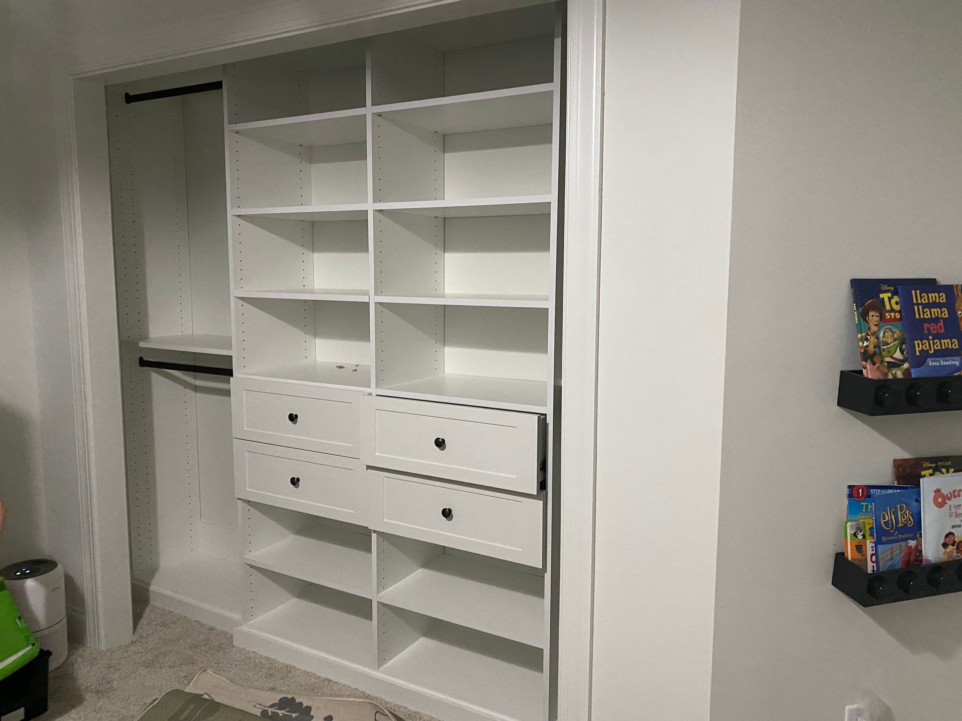 A closet with lots of shelves and drawers in a room.