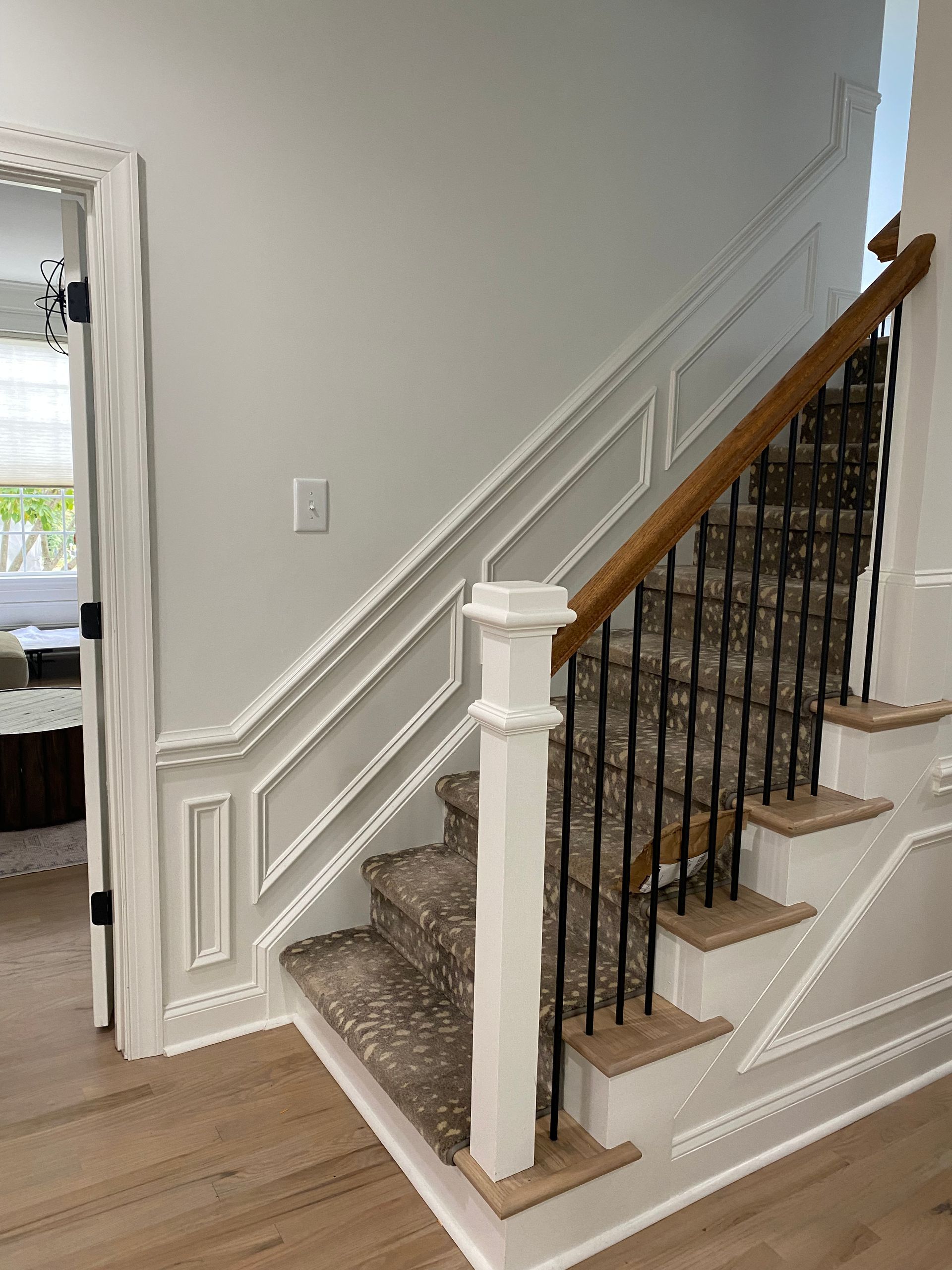 A staircase with a wooden railing and a carpeted staircase in a house.