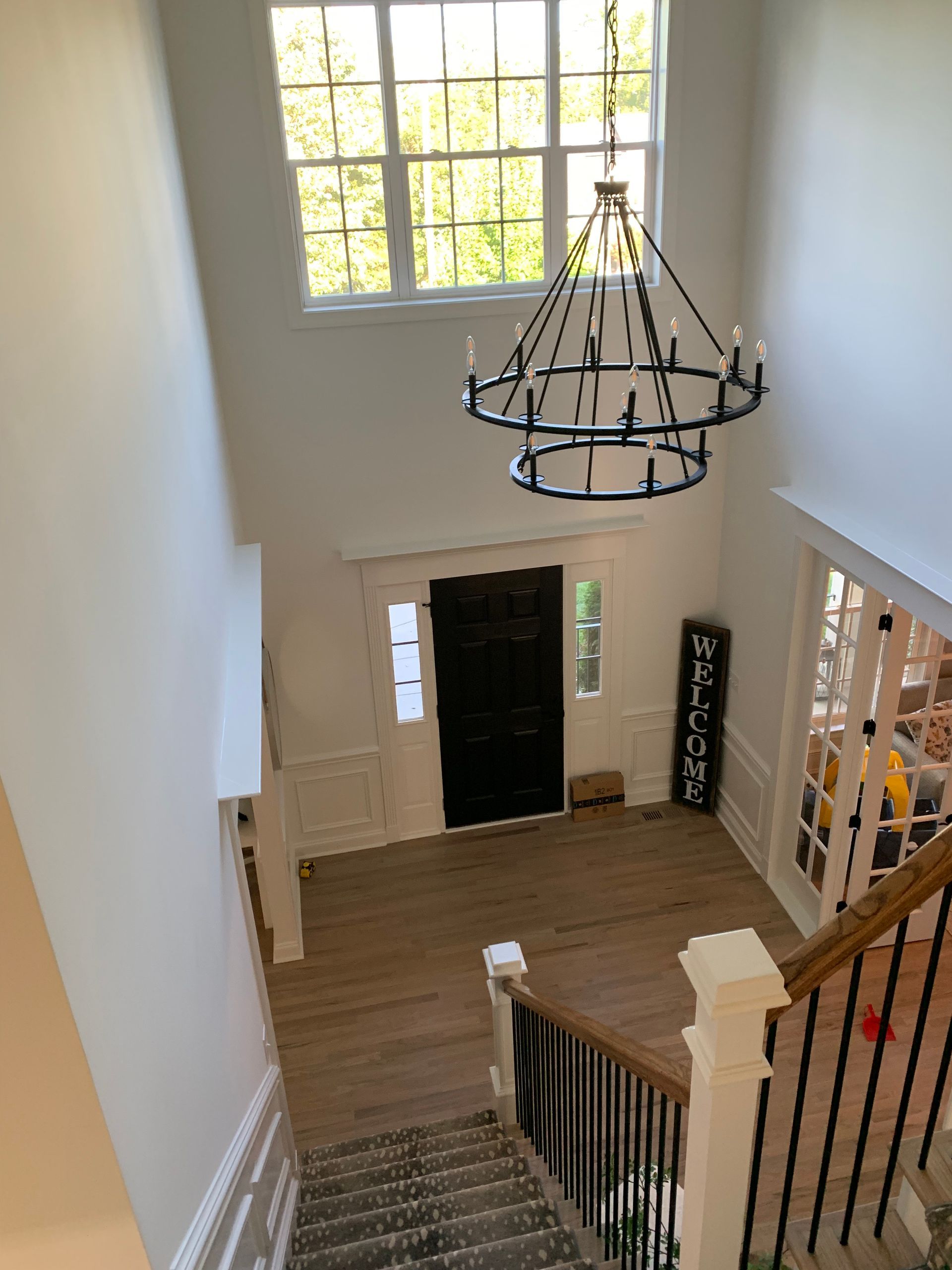 An aerial view of a hallway with stairs and a chandelier hanging from the ceiling.