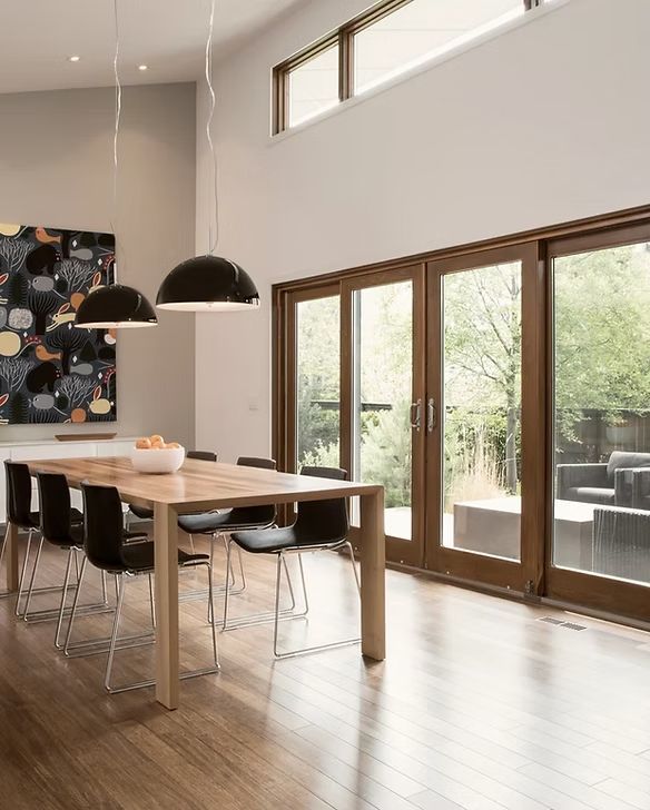 A dining room with a table and chairs and sliding glass doors
