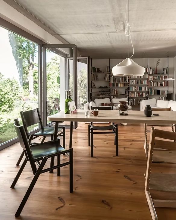 A dining room with a table and chairs and a large window