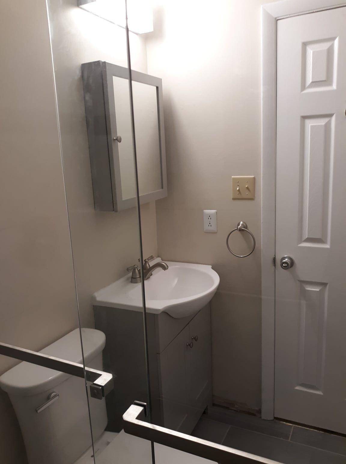 A bathroom with a sink, toilet and mirror