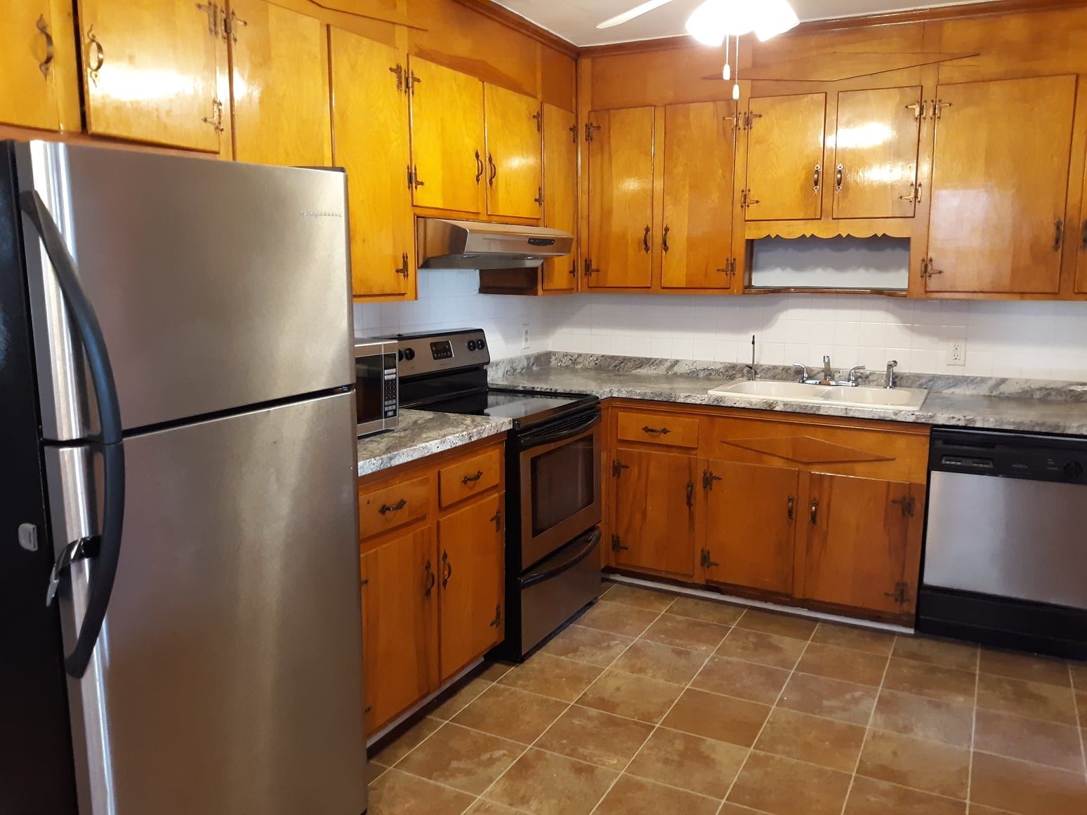 A kitchen with stainless steel appliances and wooden cabinets
