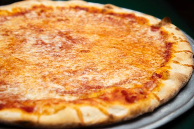 Plain cheese pizza on a metal tray; golden crust, melted cheese, red sauce.