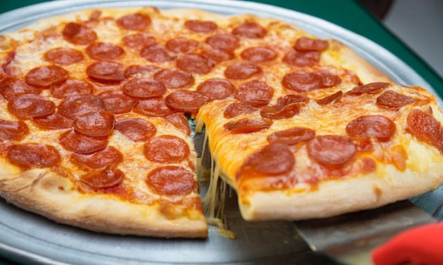 Pepperoni pizza on metal pan, slice being lifted, melted cheese, close-up shot.