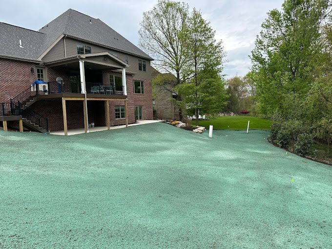 A large house with a green driveway in front of it.