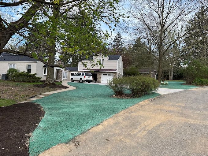 A white van is parked in a driveway next to a house.