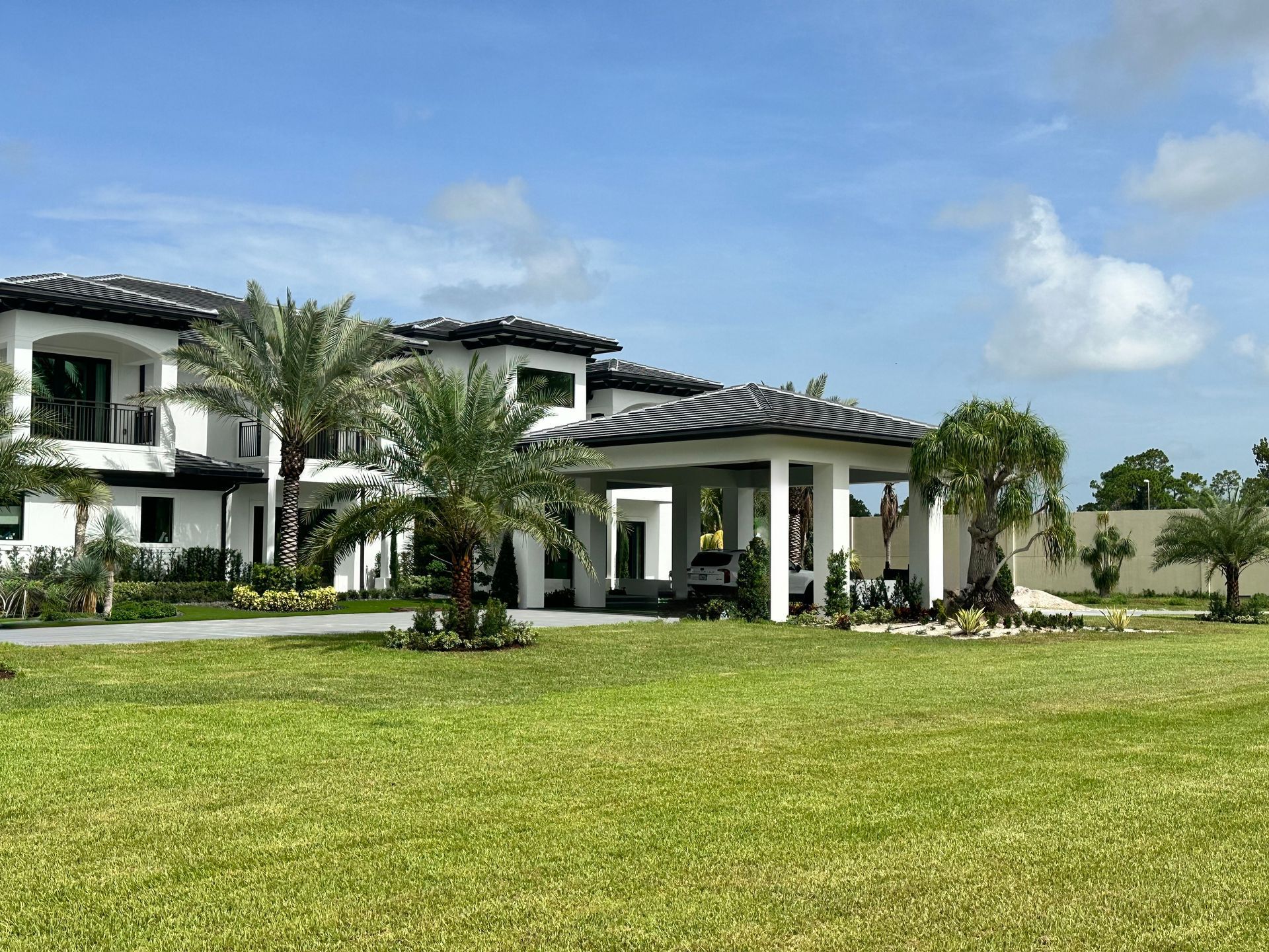 A large white house with palm trees in front of it