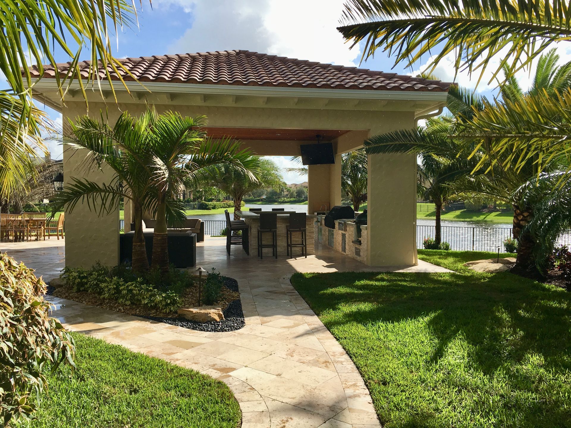 There is a gazebo in the middle of a lush green yard