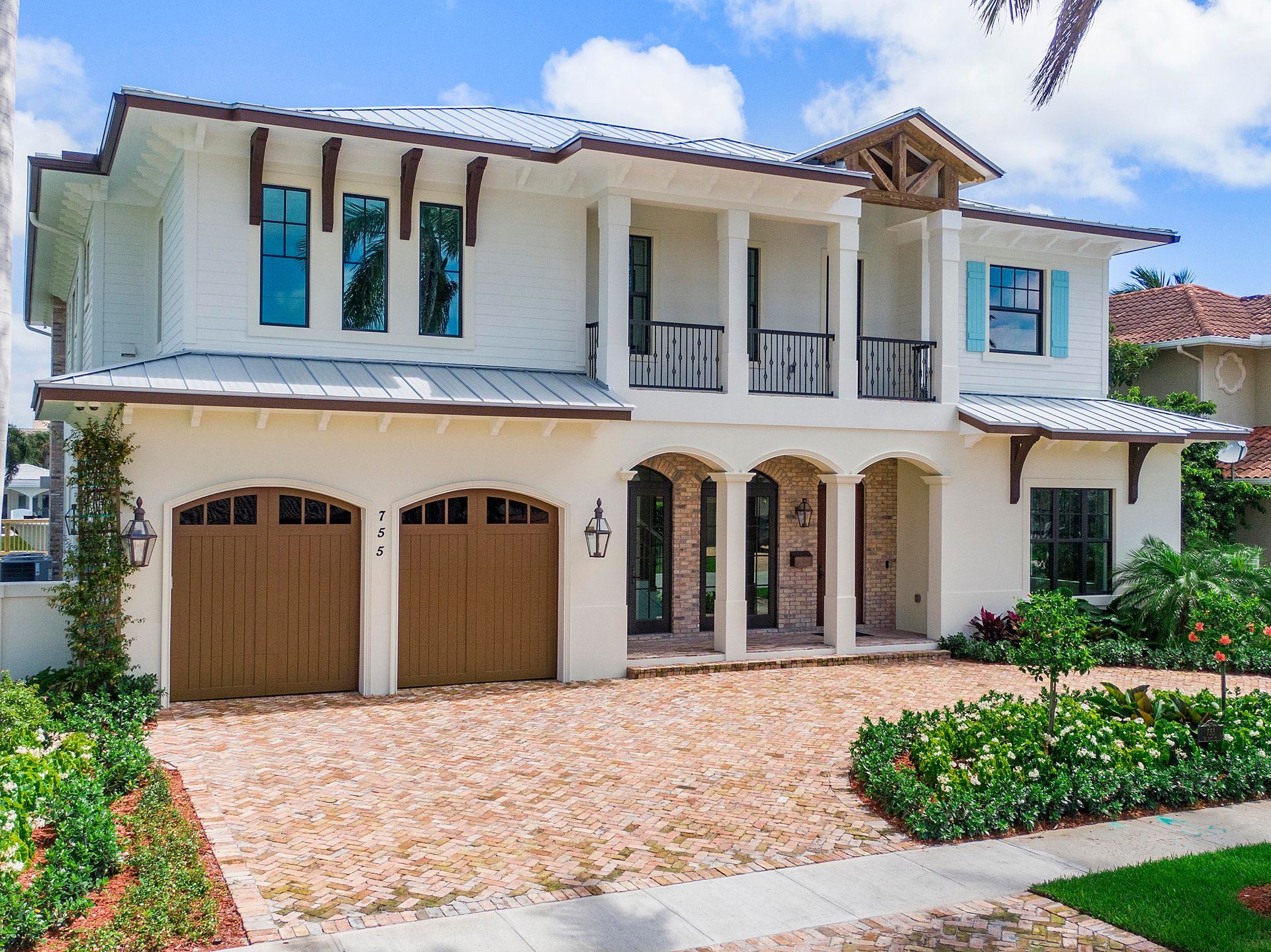 A large white house with two wooden garage doors
