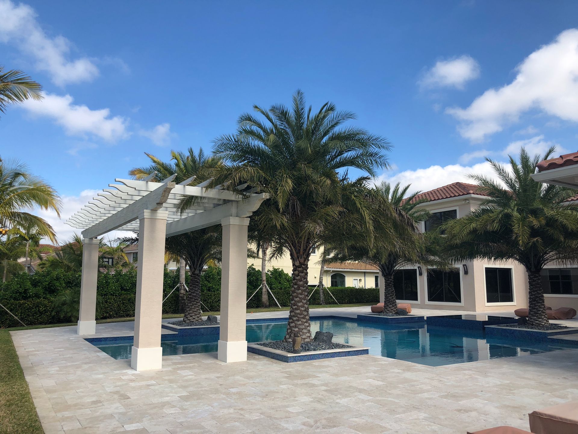 A large house with a pool and palm trees in front of it