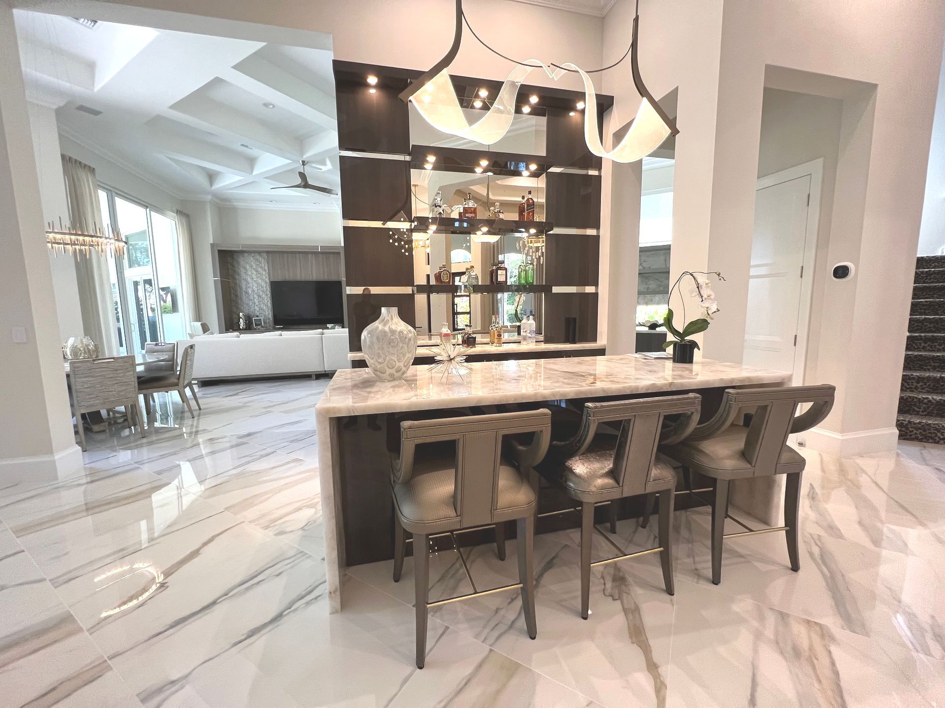 There is a bar in the middle of the room with chairs