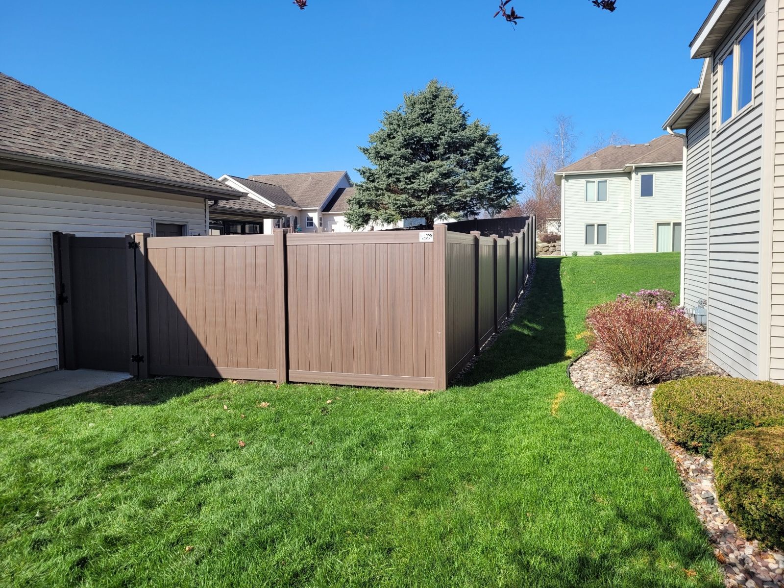 There is a wooden fence in the backyard of a house.