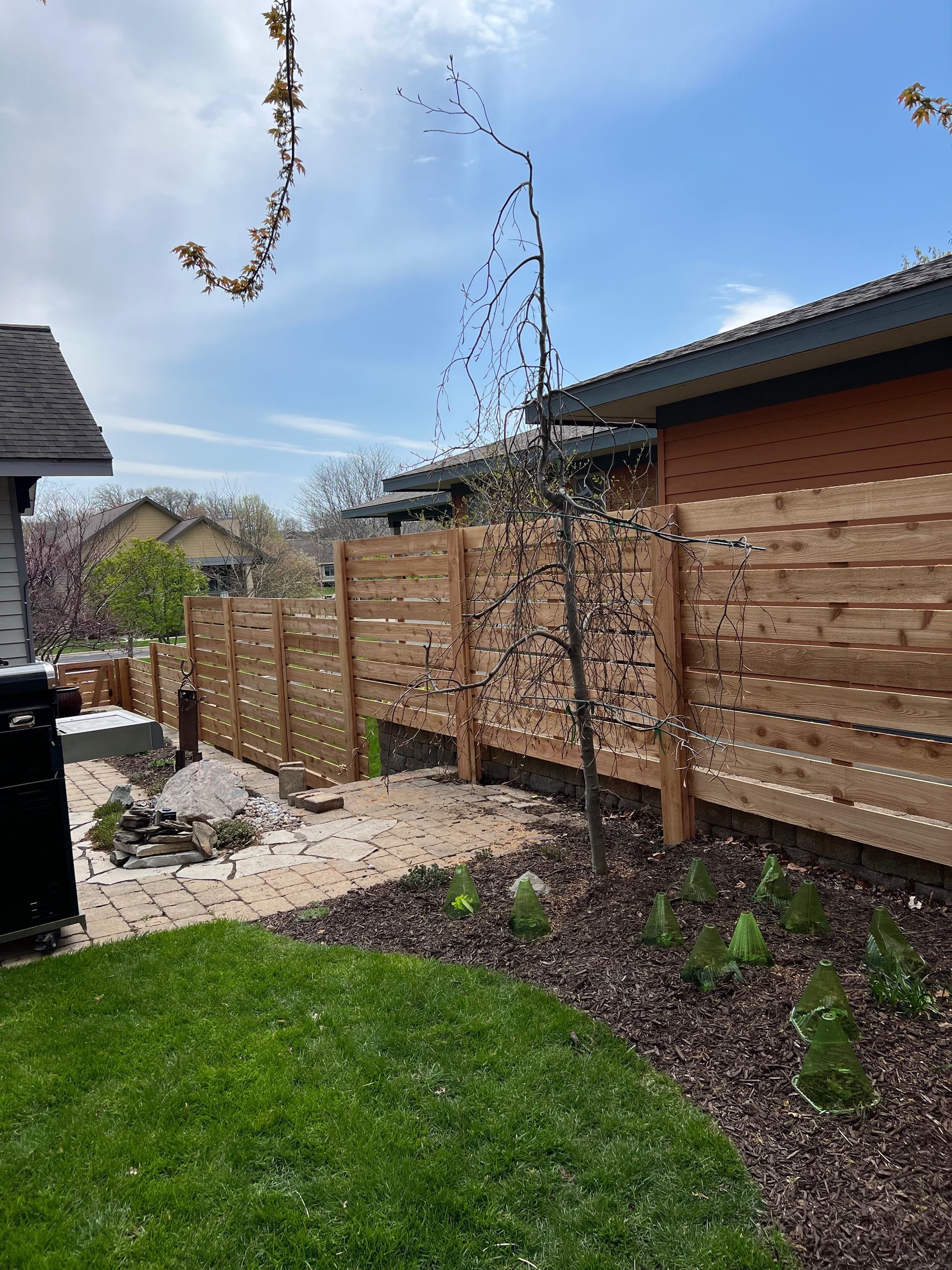 A wooden fence is in the backyard of a house.