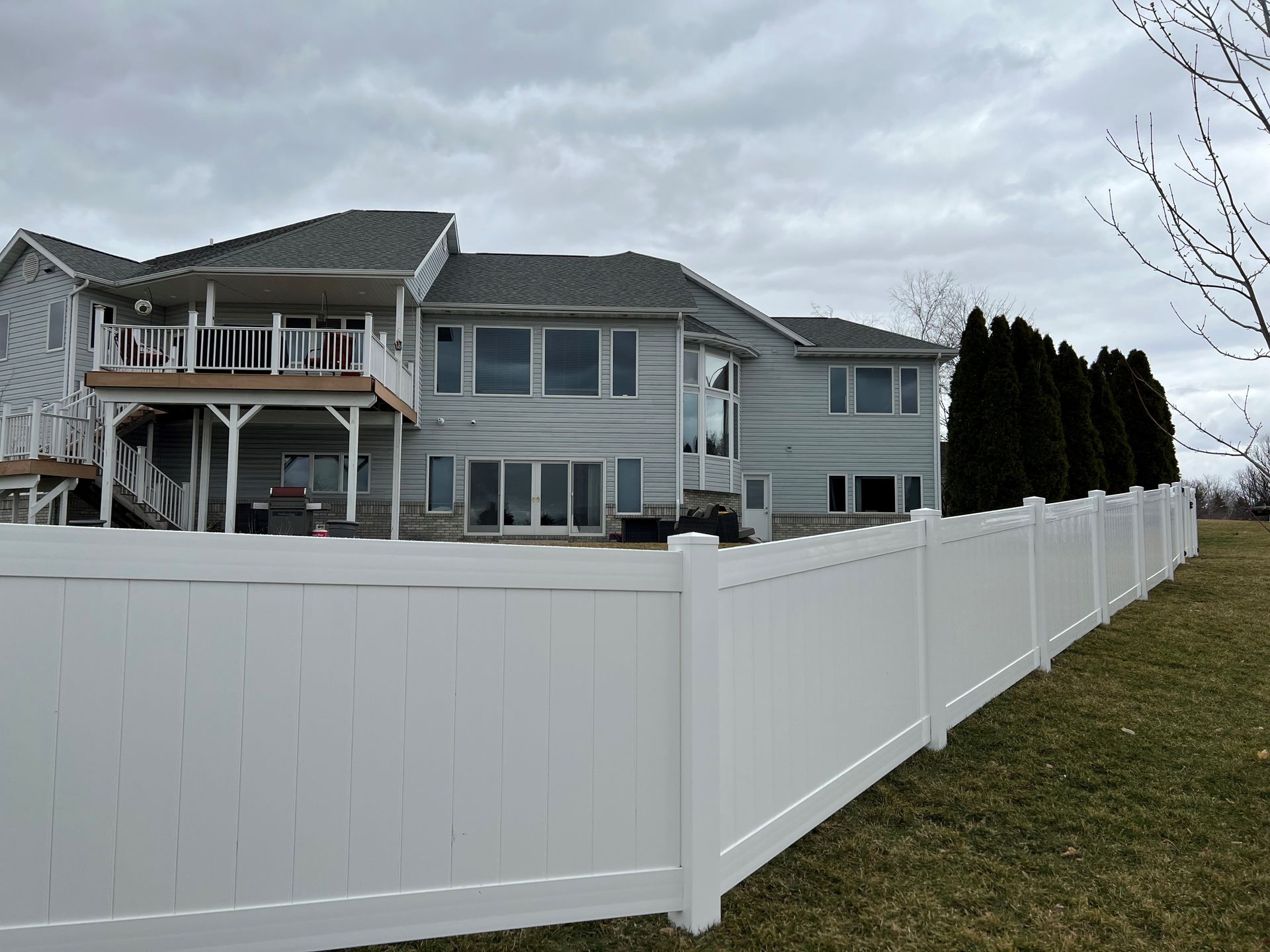 A large house with a white fence in front of it.