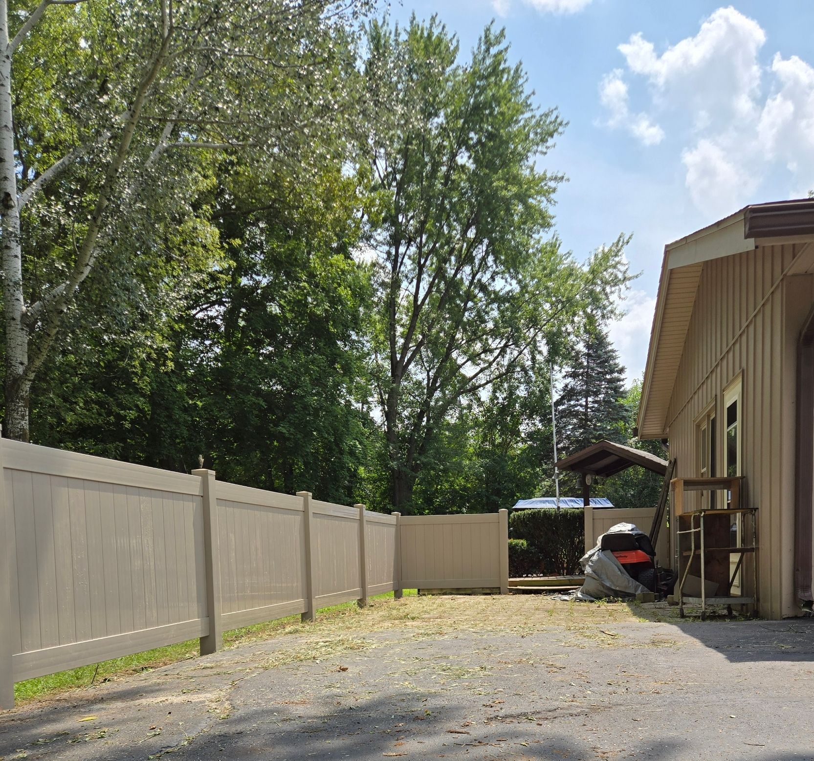 A wooden fence is in the backyard of a house.