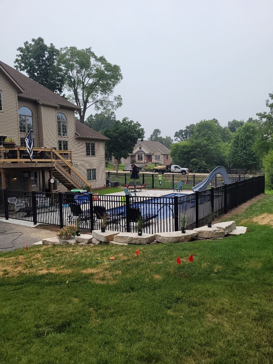 A large house with a pool in the backyard behind a fence.