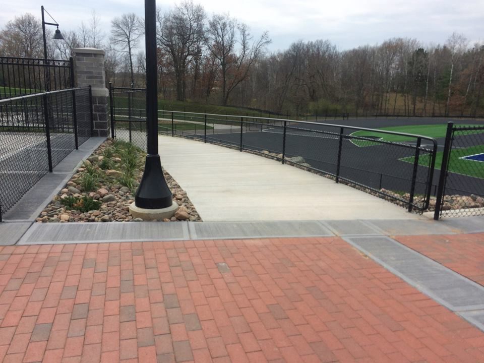 A brick walkway leading to a football field
