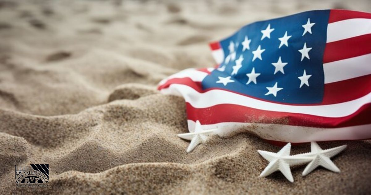 American flag draped on sand with two star decorations.
