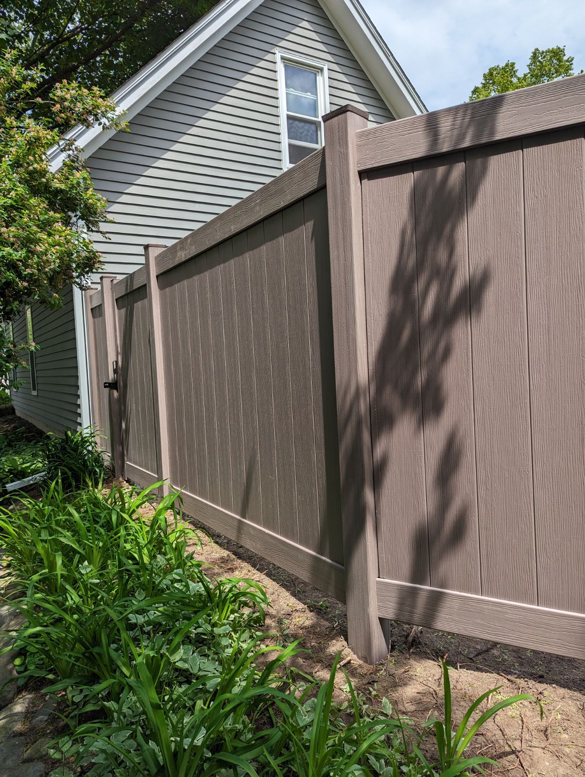 A wooden fence is sitting in front of a house.