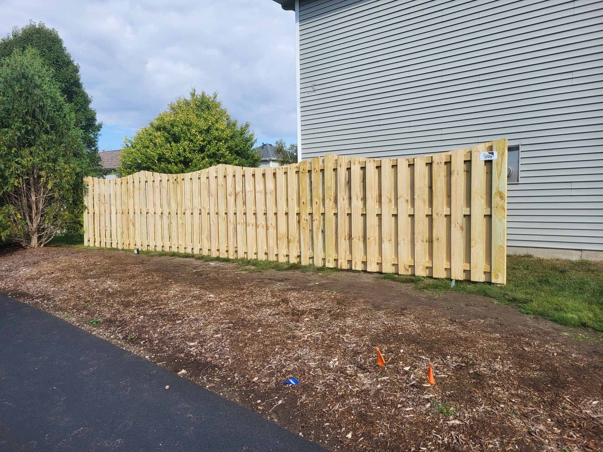 A wooden fence is sitting in front of a house.