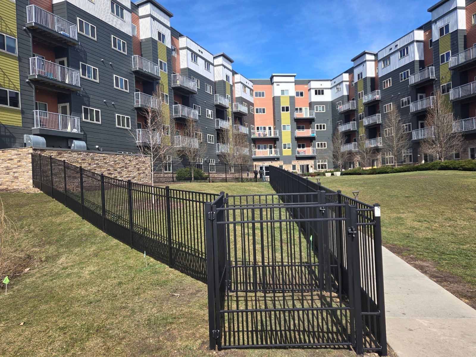 A large apartment building with a fence in front of it.