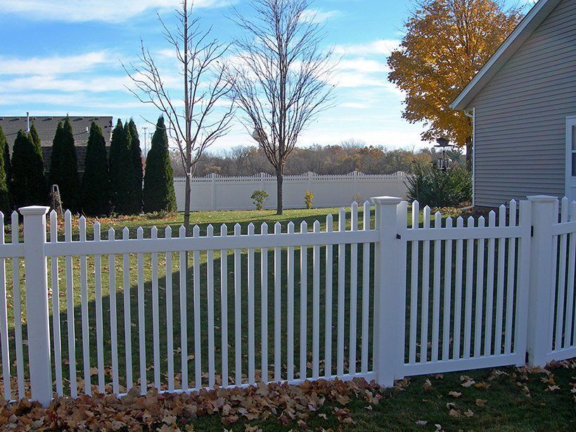 A white picket fence in front of a house