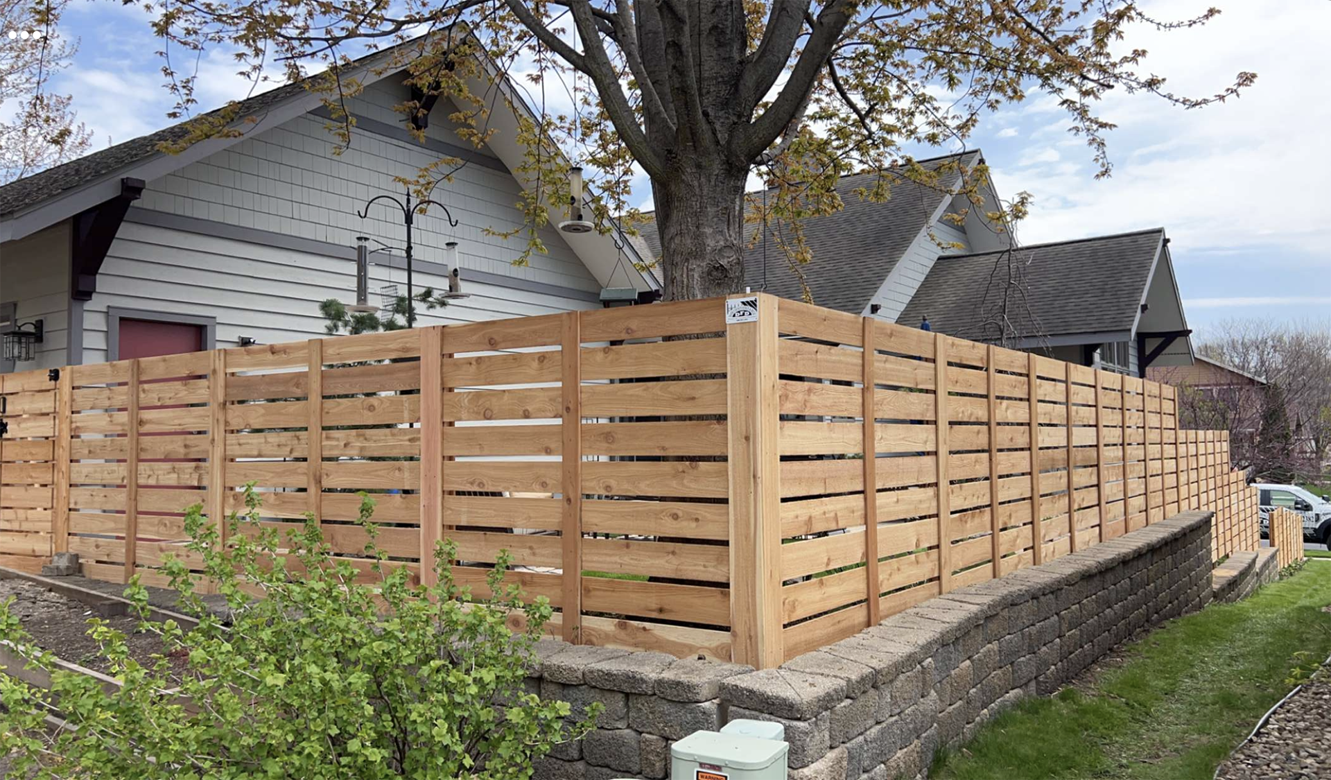 A wooden fence is being built in front of a house.
