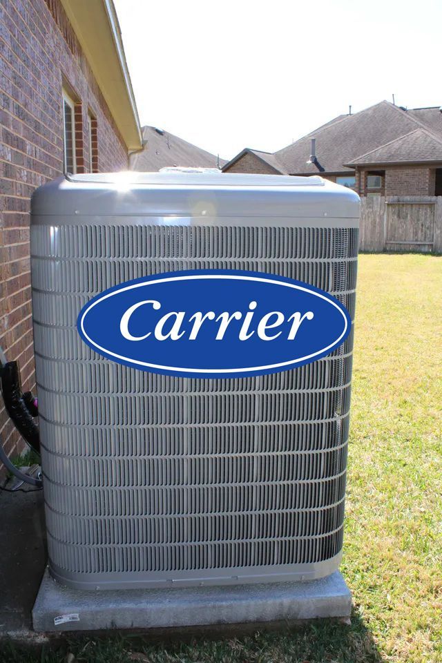 An air conditioning unit against a brick building on a sunny day.