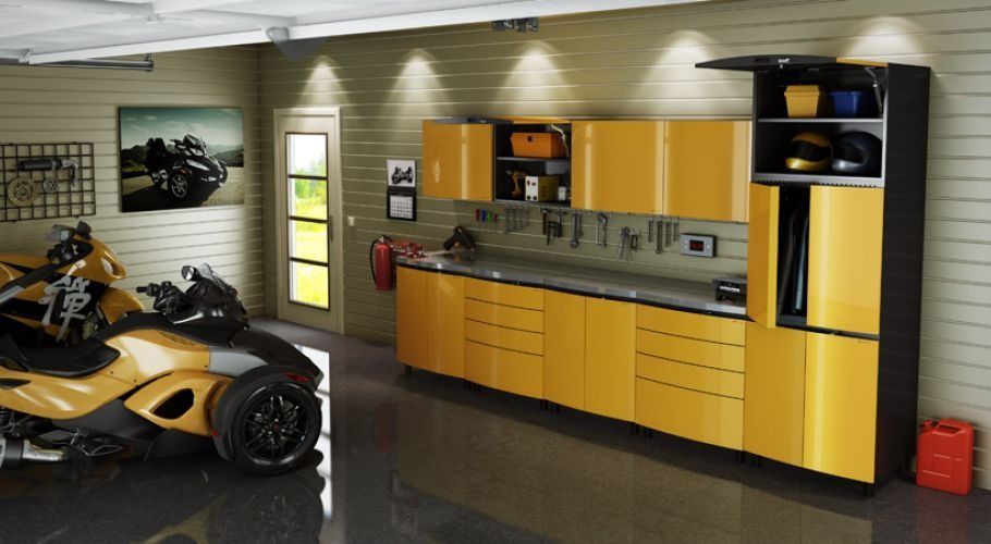 Garage with yellow cabinetry, tools, and a Can-Am Spyder. Dark gray flooring and a door.
